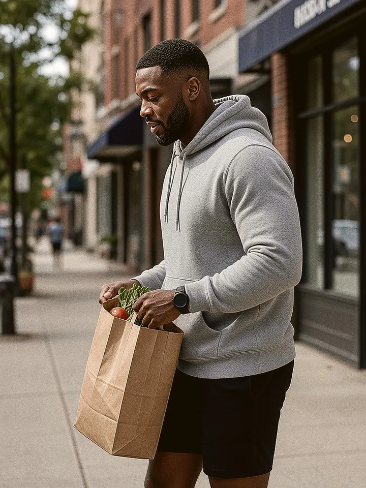 Man walking down a city street with a grocery bag